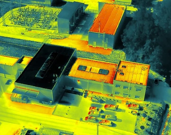 Zdjęcie termowizyjne tej samej hali z ukosa, bez odczytów temperatury: ciemniejsza część dachu z pierwszą warstwą ALBEDOX® Roof, jaśniejsza pokryta wyłącznie Primerem