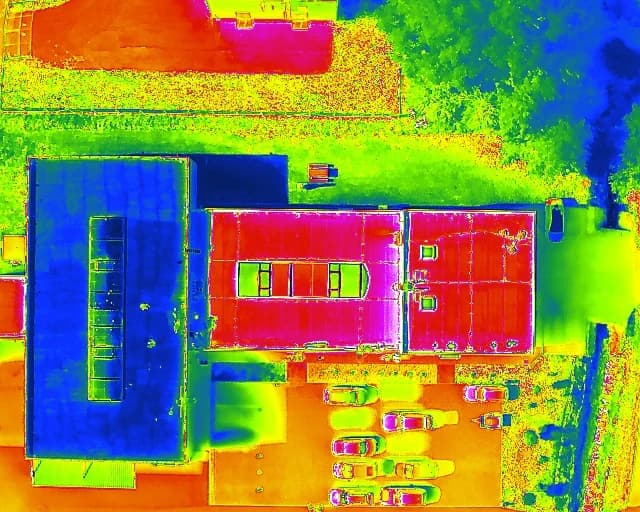Zdjęcie termowizyjne dachu hali z góry: część z pierwszą warstwą ALBEDOX® Roof w odcieniach niebieskich, część pokryta wyłącznie ALBEDOX® Primer w odcieniach czerwieni i różu, z zaznaczonymi polami pomiarowymi SQ1–SQ7